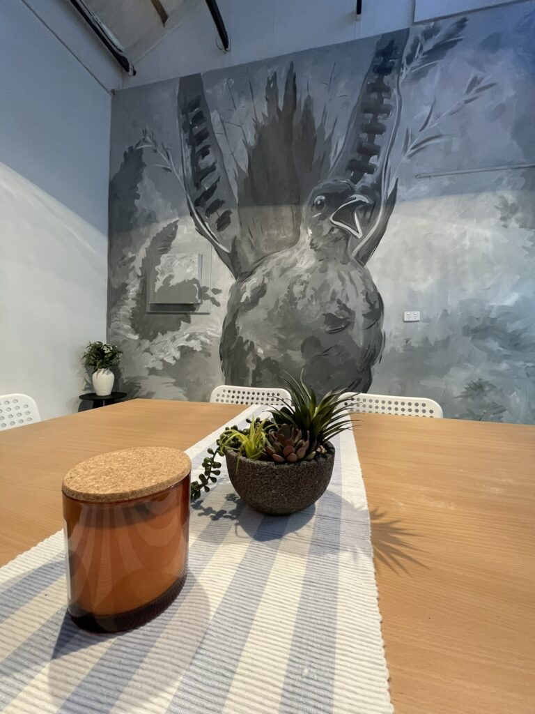Close-up of the Studio 6 bird mural behind the table